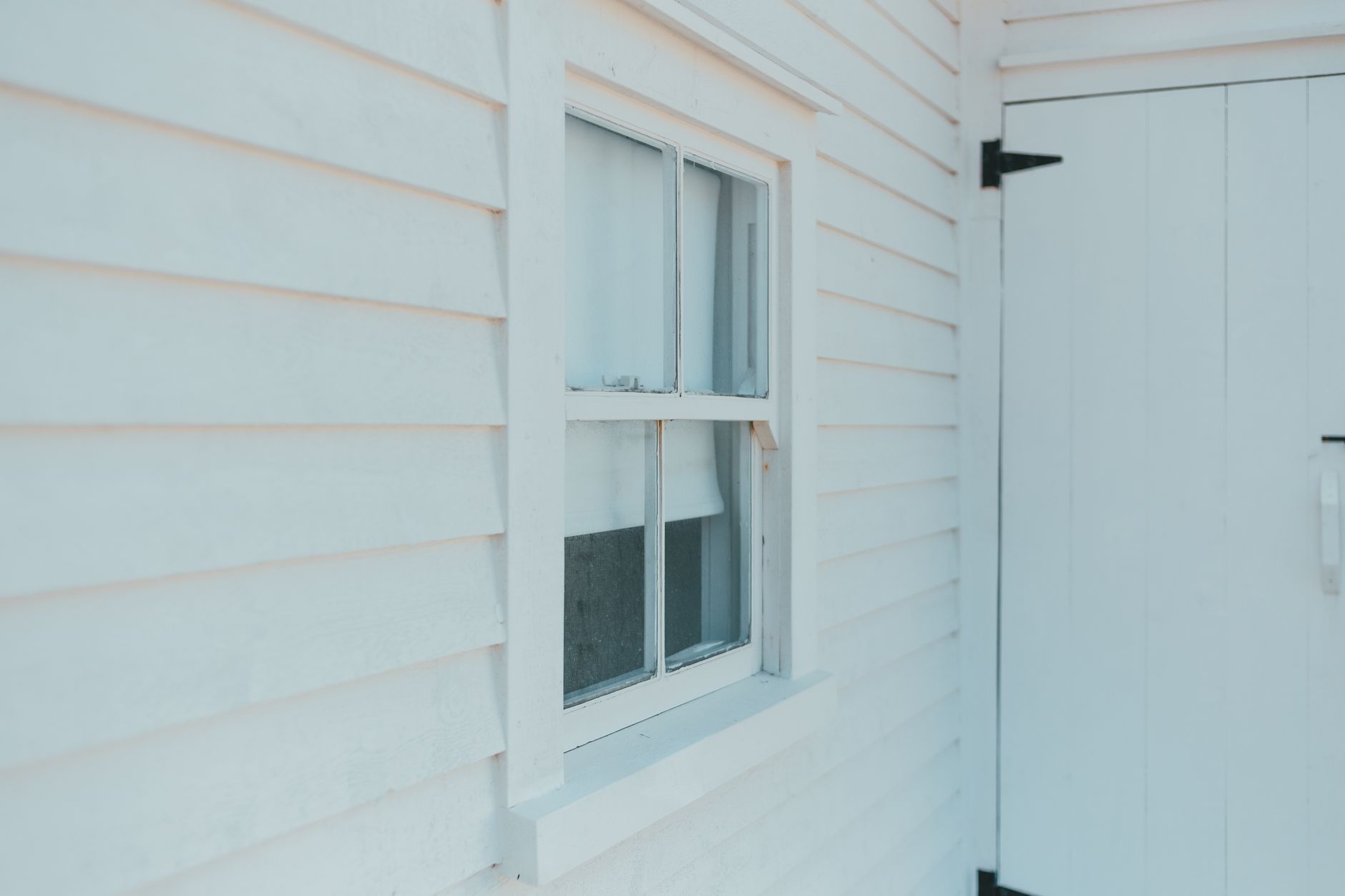 Storm-damaged vinyl siding on a New Orleans home with cracked and loose panels after a Louisiana hurricane