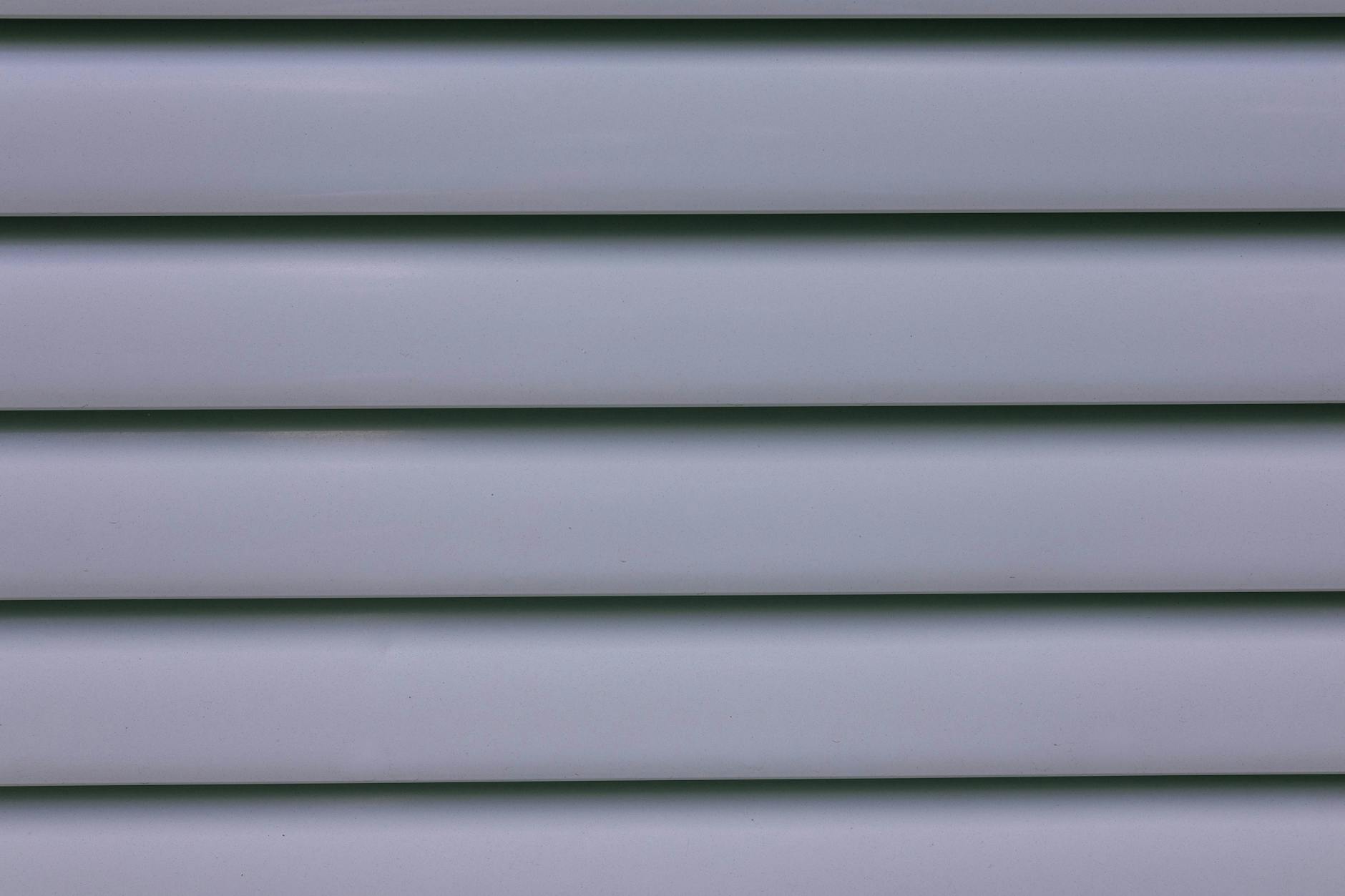 Homeowner inspecting and cleaning the siding on a New Orleans style home