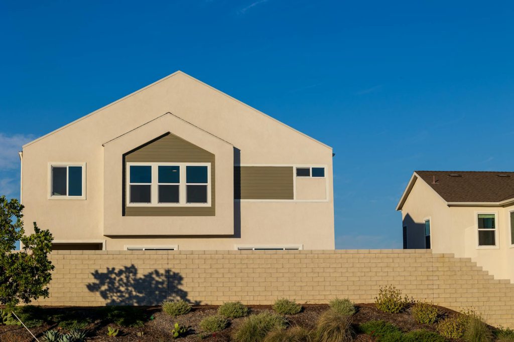Side-by-side New Orleans homes comparing stucco exterior and lap siding exterior