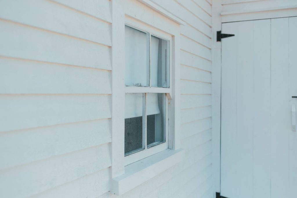 Old siding partially removed showing sheathing on a Metairie home