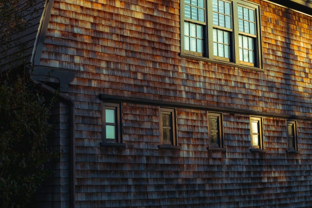 Weathered cedar shingle siding on a house wall, the look many New Orleans gables carry