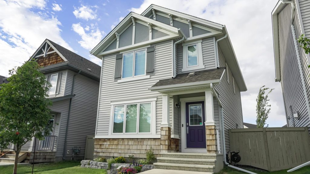 Two-story house with vinyl lap siding and cedar shake accents, one option to replace Westbank hardboard
